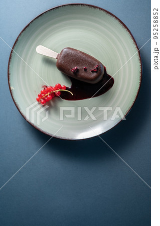 cake pop dessert or ice cream covered with chocolate on plate in cafe, top view 95258852