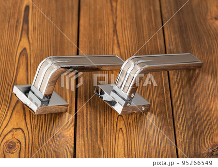 Chromed door handles for wooden doors. Door furniture, close-up 95266549