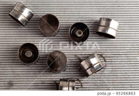 Hydraulic compensators in the lubrication system of a car engine. Knocking and increased clearance in hydraulic lifters, malfunction. Automotive Part, close-up Hydraulic compensators in the lubrication system of a car engine. Knocking and increased clearance in hydraulic lifters, malfunction. Automotive Part, close-up 95266863