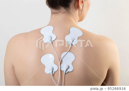 medical electric acupuncture massager on the body of a girl. Fat burning and health promotion. Physiotherapy, close-up 95266916