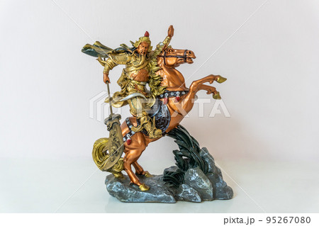 Small statue of Guan Yu on horseback riding horse for home decoration on white background 95267080