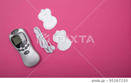 medical electric acupuncture massager in modern medicine. Treatment of body pain and fat burning, pink background. Copy space for text medical electric acupuncture massager in modern medicine. Treatment of body pain and fat burning, pink background. Copy space for text 95267230