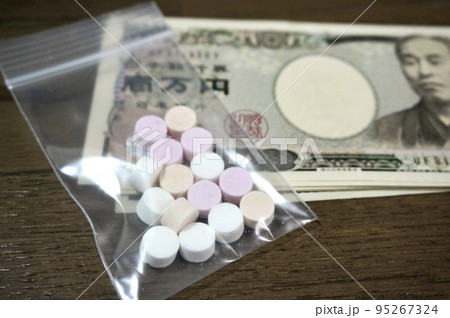 小袋に入った錠剤とお金のイメージ 小袋に入った錠剤とお金のイメージ 95267324
