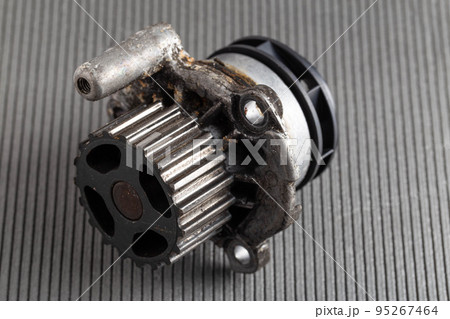 Old car pump on a gray background. The concept of repair and replacement of the pump. Automotive spare part from the cooling system, close-up 95267464