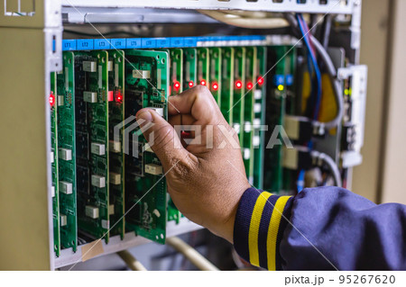 Technician or engineer changes the motherboard, PBX, telephone with flashing lights indicating the digital system connection. Select focus Technician or engineer changes the motherboard, PBX, telephone with flashing lights indicating the digital system connection. Select focus 95267620