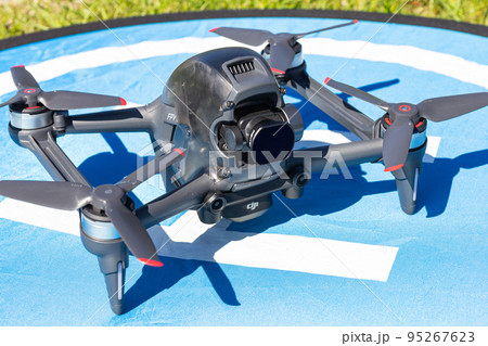 Moscow Russia - 30 may 2021: Close-up picture new aerial DJI FPV drone on fly landing pad. Top front view uav quad copter with 4K 60 fps Digital Camera and Remote control. travel in sunny summer day. Moscow Russia - 30 may 2021: Close-up picture new aerial DJI FPV drone on fly landing pad. Top front view uav quad copter with 4K 60 fps Digital Camera and Remote control. travel in sunny summer day. 95267623
