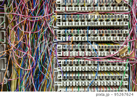Inside a PABX telephone booth that has a number of connecting cables in many colors in the analog system. Inside a PABX telephone booth that has a number of connecting cables in many colors in the analog system. 95267624