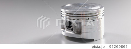 Close-up of a shiny new car piston on a gray background 95269865