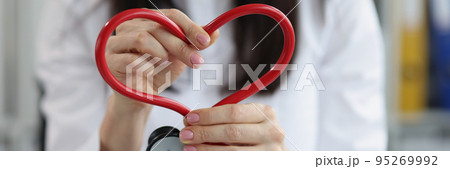 Woman doctor folded the figure heart from a stethoscope Woman doctor folded the figure heart from a stethoscope 95269992