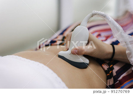 Doctor giving patient an ultrasound. Young woman getting pancreas control in moder clinic 95270769