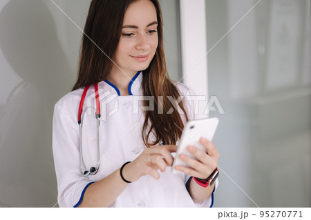 Portrait of youg female doctor using phone during break in clicic 95270771
