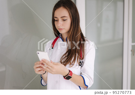 Portrait of youg female doctor using phone during break in clicic 95270773