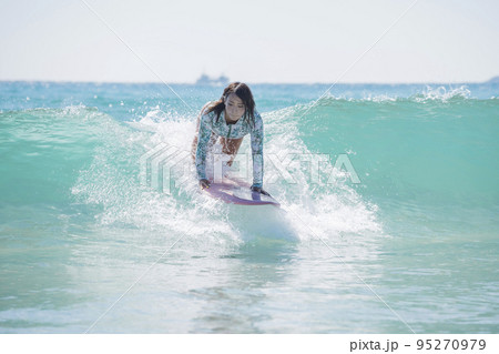 海でサーフィンをする女性若い女性　テイクオフの瞬間　サーフ女子　サーフィン女子 95270979