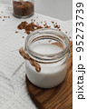 Glass jar with vegan milk from buckwheat on wooden board. Home cooking alternative food. conscious balanced nutrition. Animal friendly and eco eating concept. Soft focus, close-up. 95273739