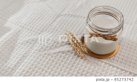 Morning breakfast preparation - making vegan milk. Jar with alternative milk on wooden board. non-allergic, no lactose dairy product. Healthy eating concept. soft focus, copy space. 95273742