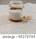 Glass jar with vegan milk, wheat. ingredients for making alternative dairy product. self care concept. healthy eating. no allergy, lactose free. close-up, selective focus 95273743