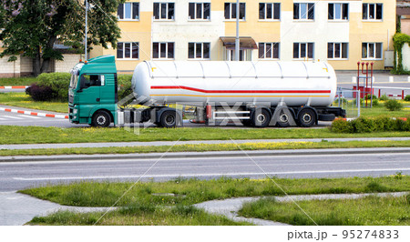 A truck with a semi-trailer tank for the transport of gasoline and diesel drains fuel at a gas station. Dangerous goods, flammable. ADR 95274833