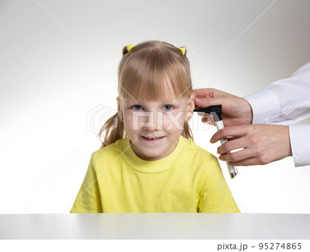 An otolaryngologist examines the ear of a child girl at the age of 5 years. Otoscopy, copy space for text An otolaryngologist examines the ear of a child girl at the age of 5 years. Otoscopy, copy space for text 95274865