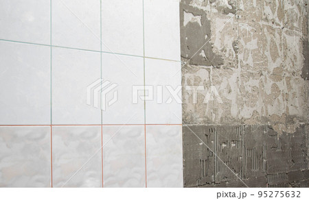 Dismantling old tiles from the walls in the kitchen. Cleaning and preparing walls from old tile adhesive. Copy space for text 95275632