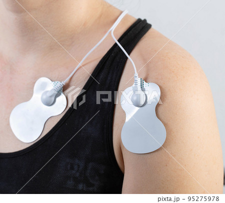 medical electric acupuncture massager on the body of a girl. Fat burning and health promotion. Physiotherapy, close-up 95275978