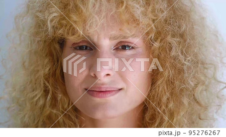 Confident portrait of an attractive charming curly redhead young woman with fresh and radiant skin smiling sweetly looking at the camera. Beautiful diverse people, femininity, human face. Headshot 95276267