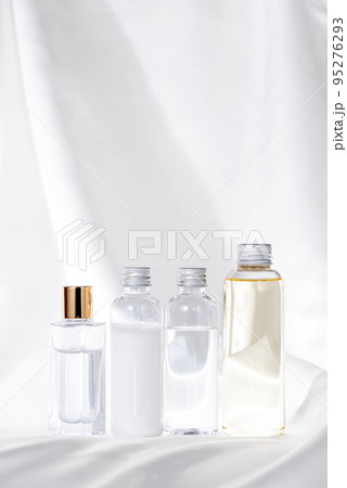 白いサテン生地と化粧品ボトル4個の整列 白いサテン生地と化粧品ボトル4個の整列 95276293