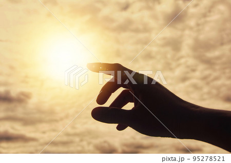 Hand reaching out to bright shining light. Hand reaching out to bright shining light. 95278521