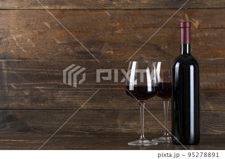Wine bottle and two glasses on a wooden background. Wine bottle and two glasses on a wooden background. 95278891