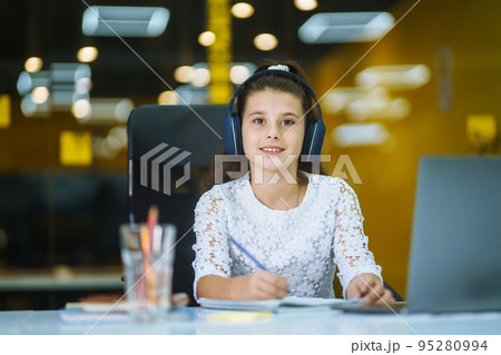 Online education. School girl using laptop computer studying through online e-learning system. 95280994