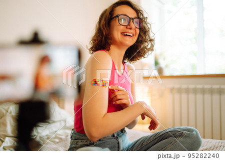 Woman blogger videotapes her vlog at home and speaking about Vaccine for covid-19. 95282240