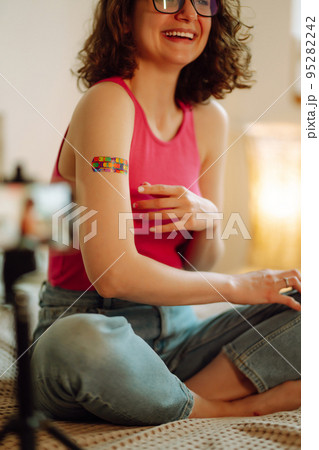 Woman blogger videotapes her vlog at home and speaking about Vaccine for covid-19. 95282242