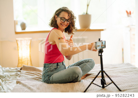 Woman blogger videotapes her vlog at home and speaking about Vaccine for covid-19. 95282243