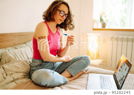 Woman blogger videotapes her vlog at home and speaking about Vaccine for covid-19. 95282245