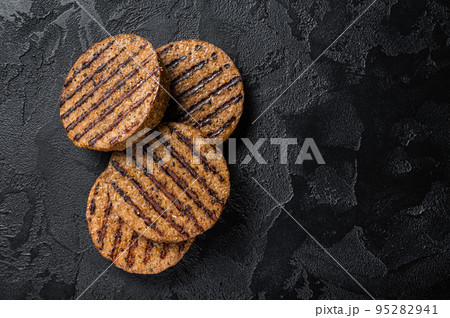 Griiled meat free patties, plant based meat steak cutlets. Black background. Top view. Copy space 95282941