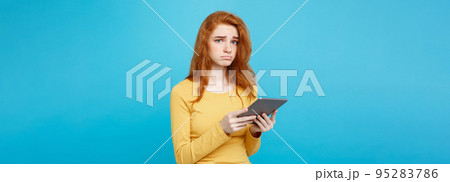 People and Technology Concept - Close up Portrait young beautiful attractive tender ginger redhair girl shocking and sad on digital table with wining something. Blue Pastel Background. Copy space. People and Technology Concept - Close up Portrait young beautiful attractive tender ginger redhair girl shocking and sad on digital table with wining something. Blue Pastel Background. Copy space. 95283786