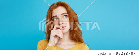 Headshot Portrait of happy ginger red hair girl with freckles smiling looking at camera. Pastel blue background. Copy Space. Headshot Portrait of happy ginger red hair girl with freckles smiling looking at camera. Pastel blue background. Copy Space. 95283787