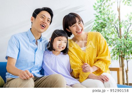 リビングでくつろぐ若い家族 95290158