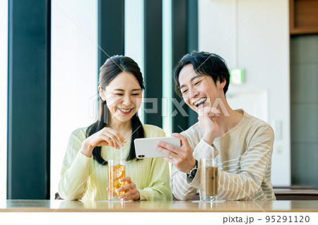 カフェで動画を見る若いカップル　 95291120