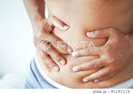 young man suffering stomach pain close up. young man suffering stomach pain close up. 95292119