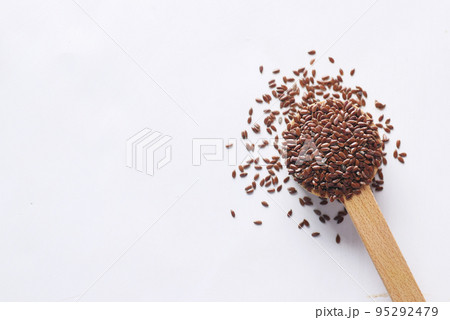 top view of flax seeds on wooden spoon on table  95292479