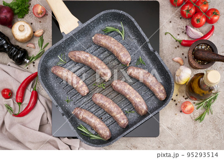 Grilled sausages on a grill frying pan on a domestic kitchen 95293514