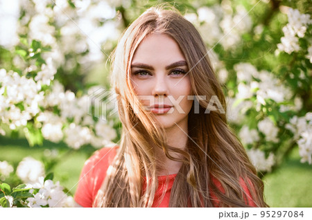 Beautiful young woman in summer garden Beautiful young woman in summer garden 95297084