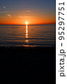 水平線上の太陽と海面に反射する光の道 95297751