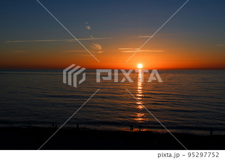 水平線上の太陽と海面に反射する光の道 95297752