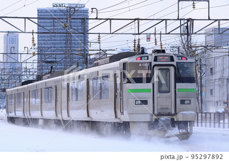 軽く雪煙をまといながら走行する735系電車（後追い） 95297892