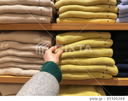Woman's hand chooses a sweater for the winter 95300268