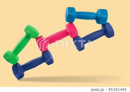 Five dumbbells of different colors, lined up in a complex geometric figure, seem to be in a fall, concept Five dumbbells of different colors, lined up in a complex geometric figure, seem to be in a fall, concept 95302495