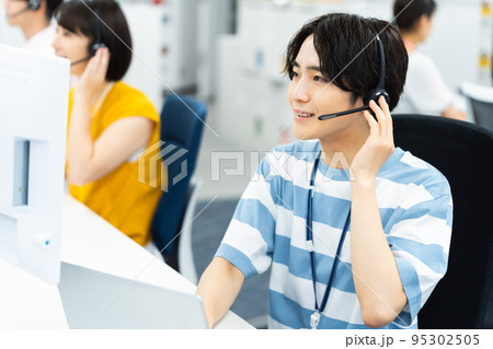 コールセンターで働く若い男性 コールセンターで働く若い男性 95302505
