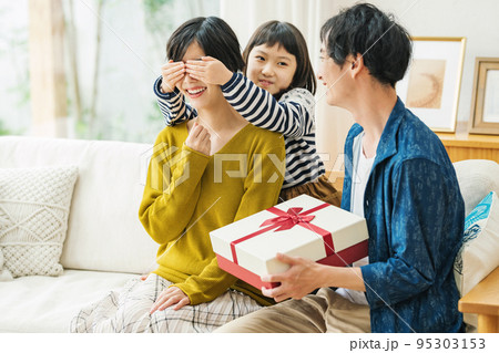 ママに内緒でプレゼントを用意する家族 95303153
