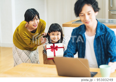 パパにサプライズでプレゼントを渡そうとする女の子 95303249